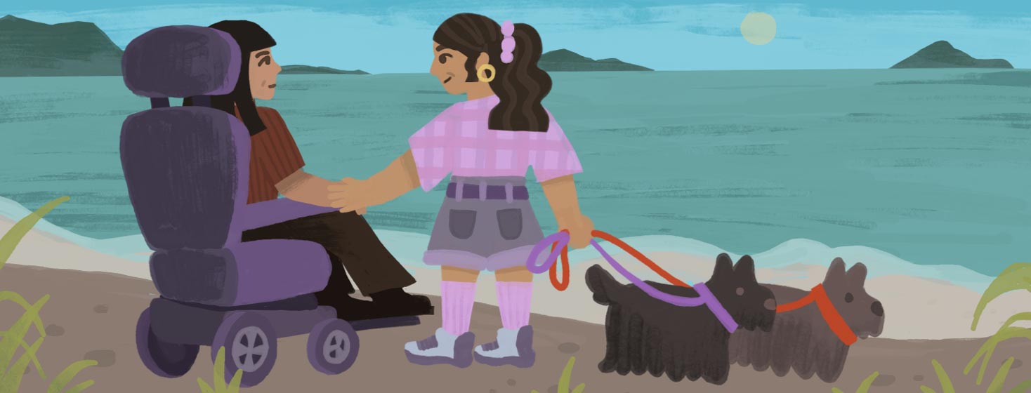 Adult female sits in her motorized wheelchair next to her wife and two dogs by the Scottish seashore. Travel, mobility, beach